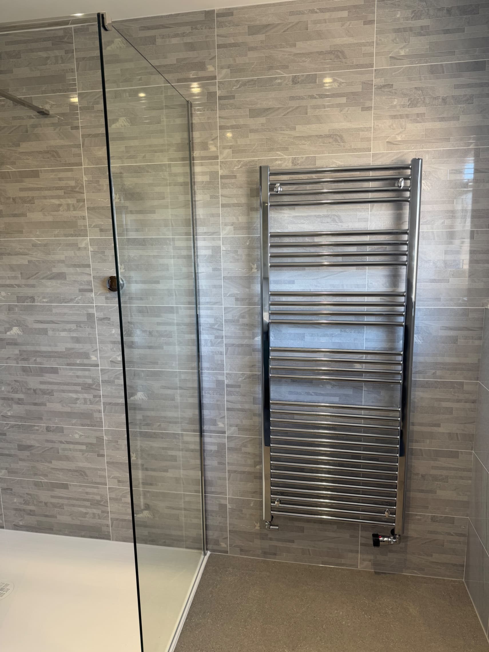 We've installed the shower screen and heated towel rail, with the tiling complete and all the fittings in place.